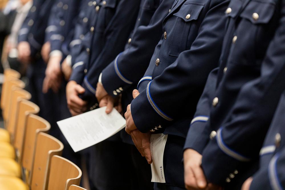 Police officers giving their ethical oath, standing in line in their ceremonial uniform.
