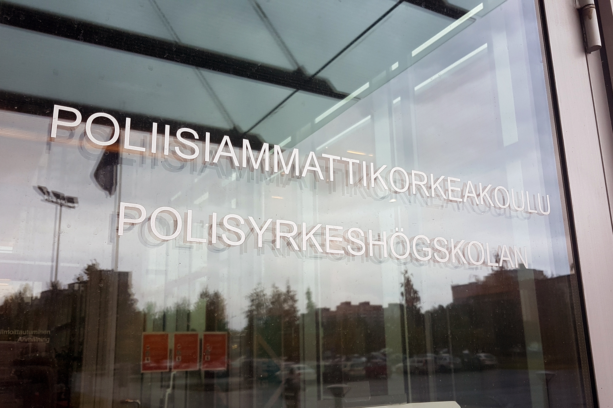 The glass front door of the Police University College, which reads ‘Poliisiammattikorkeakoulu Polisyrkeshögskolan’.