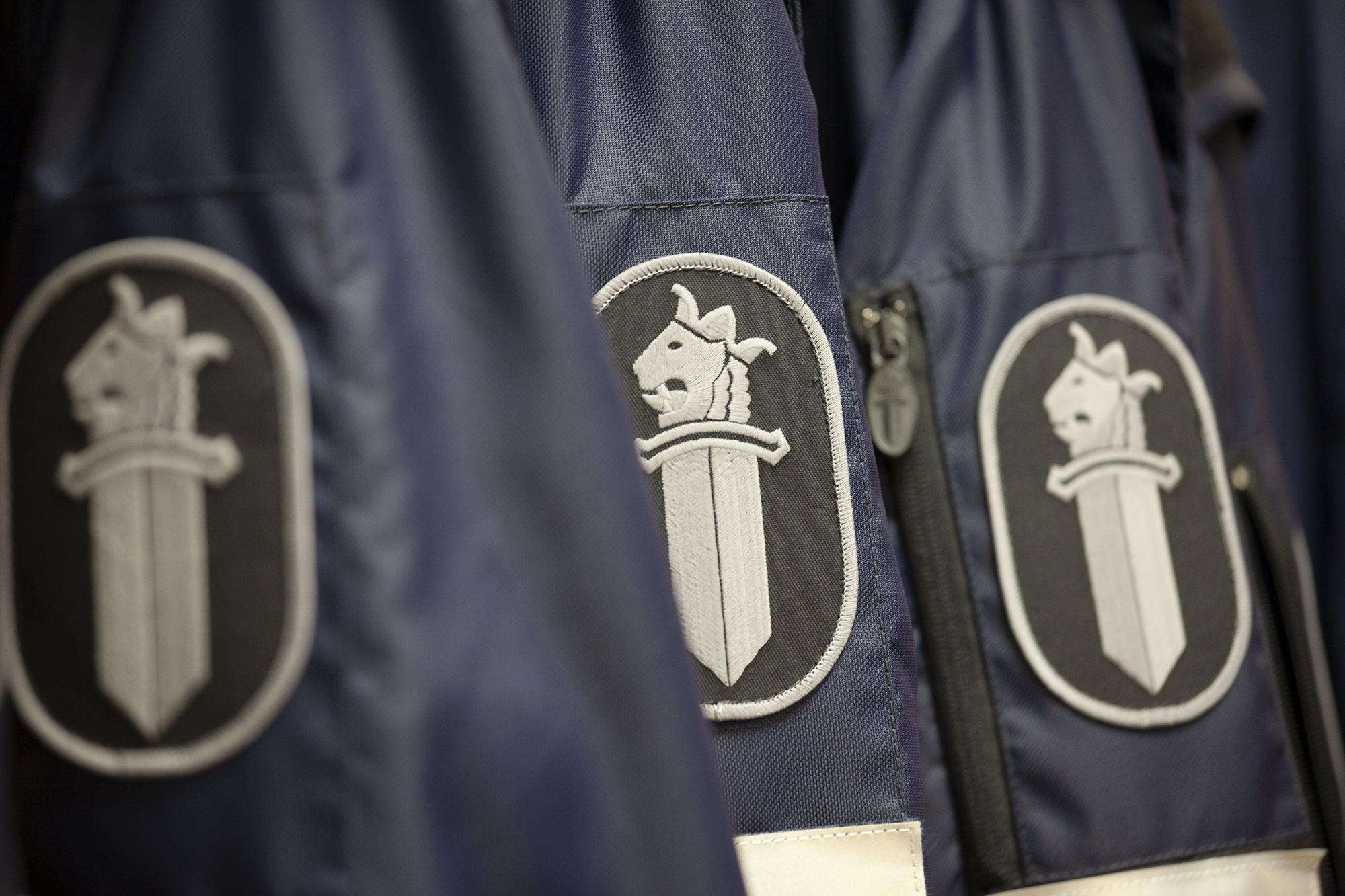 Sleeve badges on police overalls showing the emblem of the Finnish police.