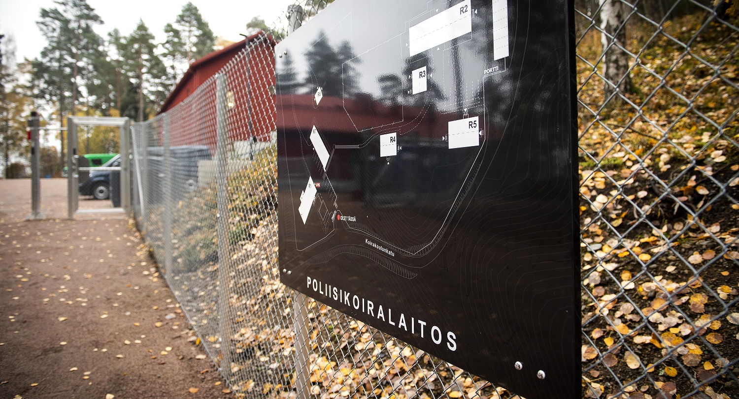 Poliisikoiralaitoksen kyltti aidassa.